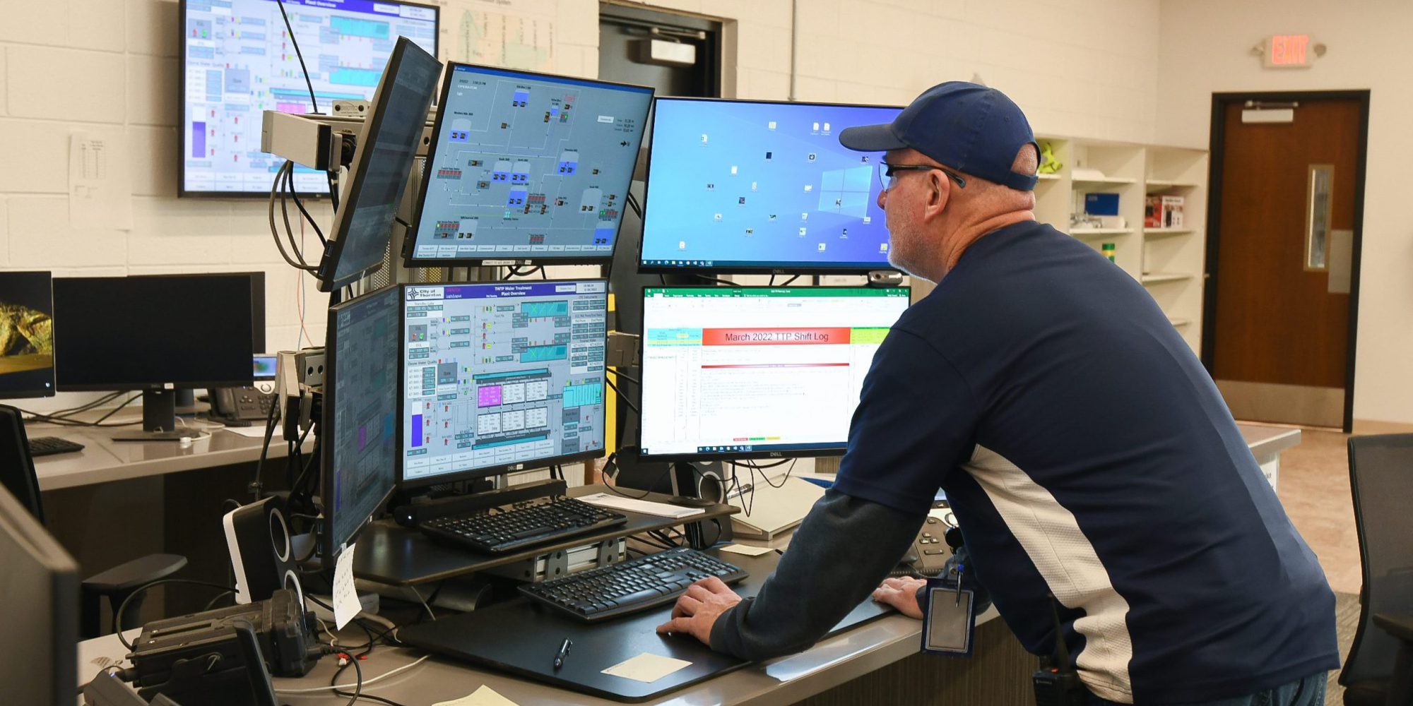 Male employee viewing a six-screen computer to monitor water at the Thornton water treatment facility.